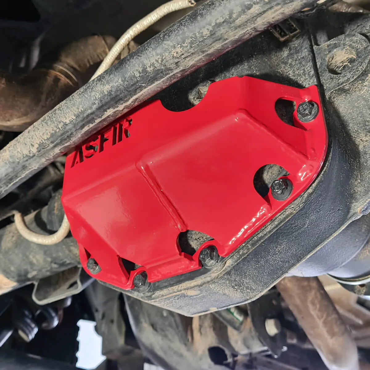 Red ASFIR differential skid plate installed on a Toyota axle