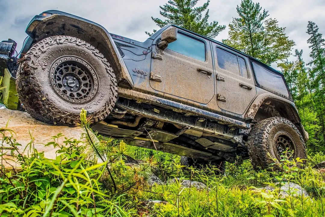 Toyota Wrangler Unlimited climbing a ledge in the forest
